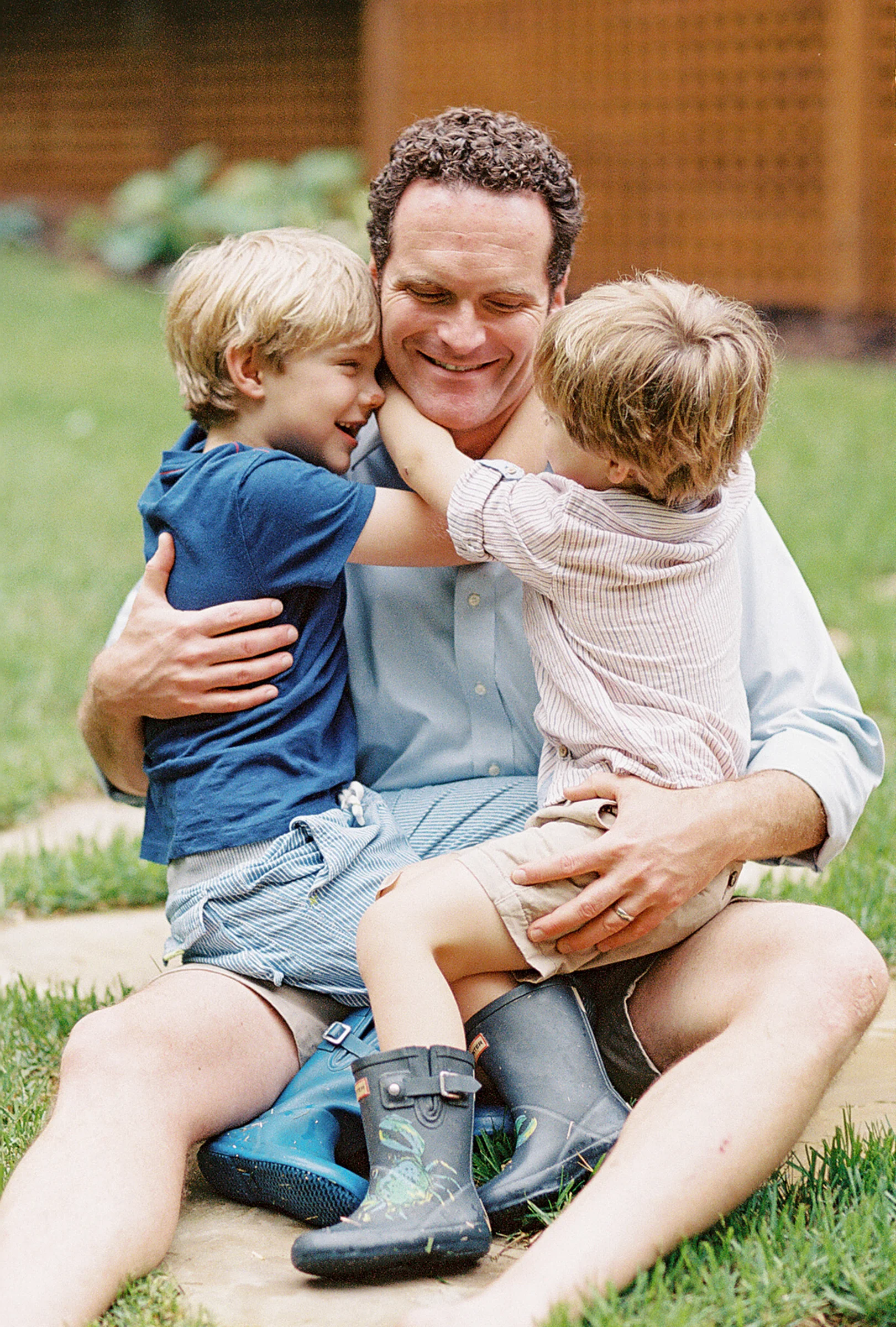 a candid moment of father and sons captured on film by photographer anna laero at a pittsburgh family session