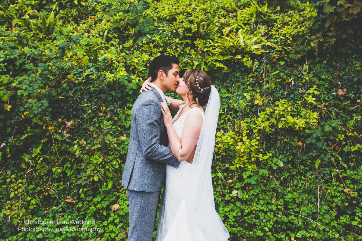 A colourful wedding photo of a lush bride and groom at St Donat's