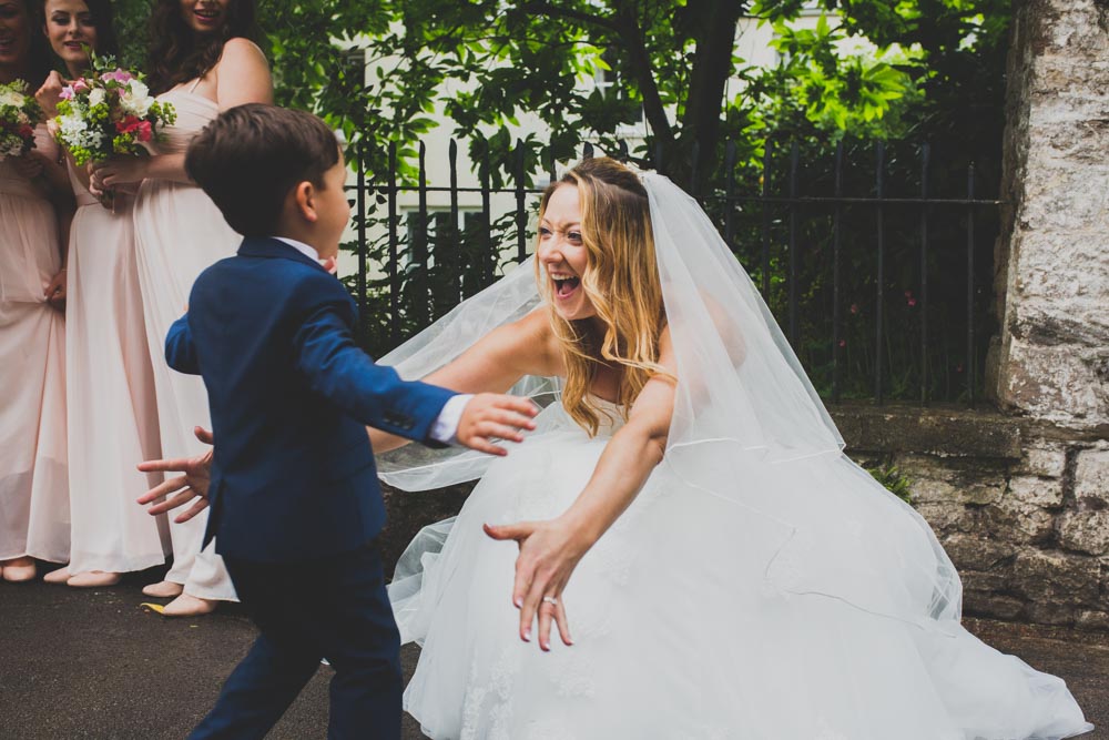 The Bride is crying with joy and hugs her ring bearer | Best South Wales Wedding Photographers