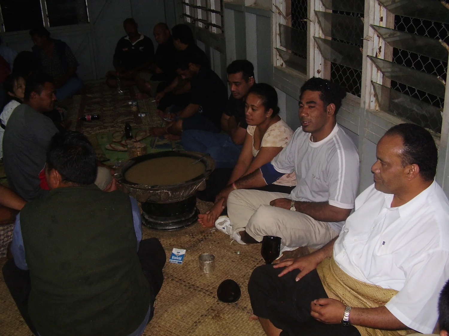 Pic: The female custodian of the Kava pot, surrounded by the male drinkers