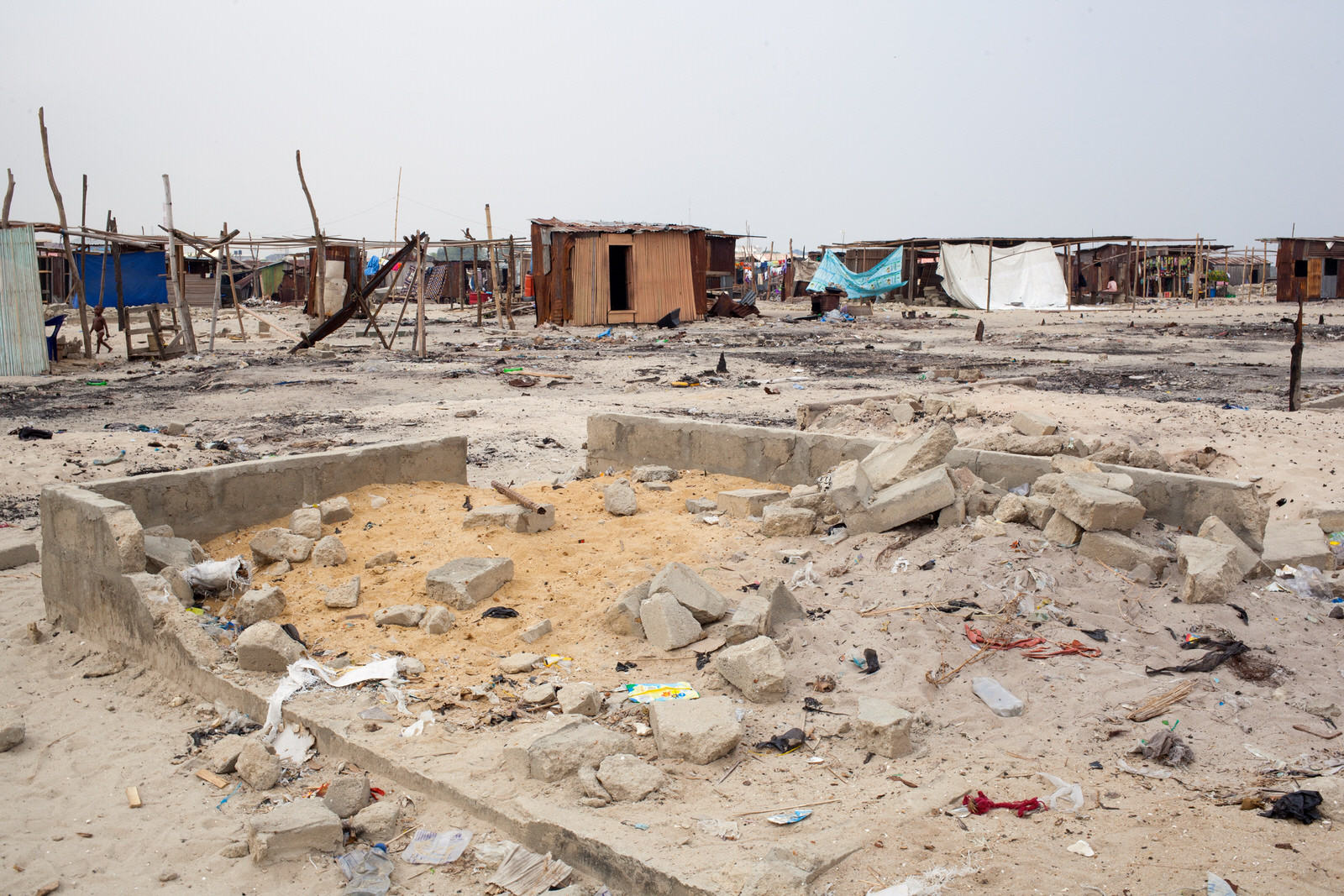  Remaining and new buildings sit amongst the rubble of homes razed by 'hoodlums' sent into the community. 