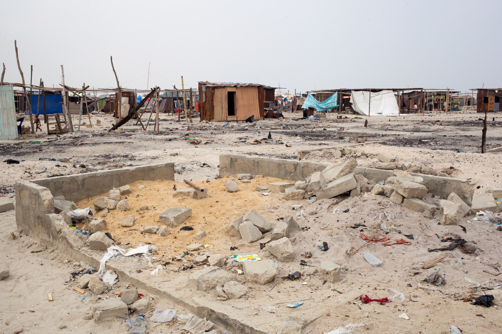 Remaining and new buildings sit amongst the rubble of homes razed by 'hoodlums' sent into the community.