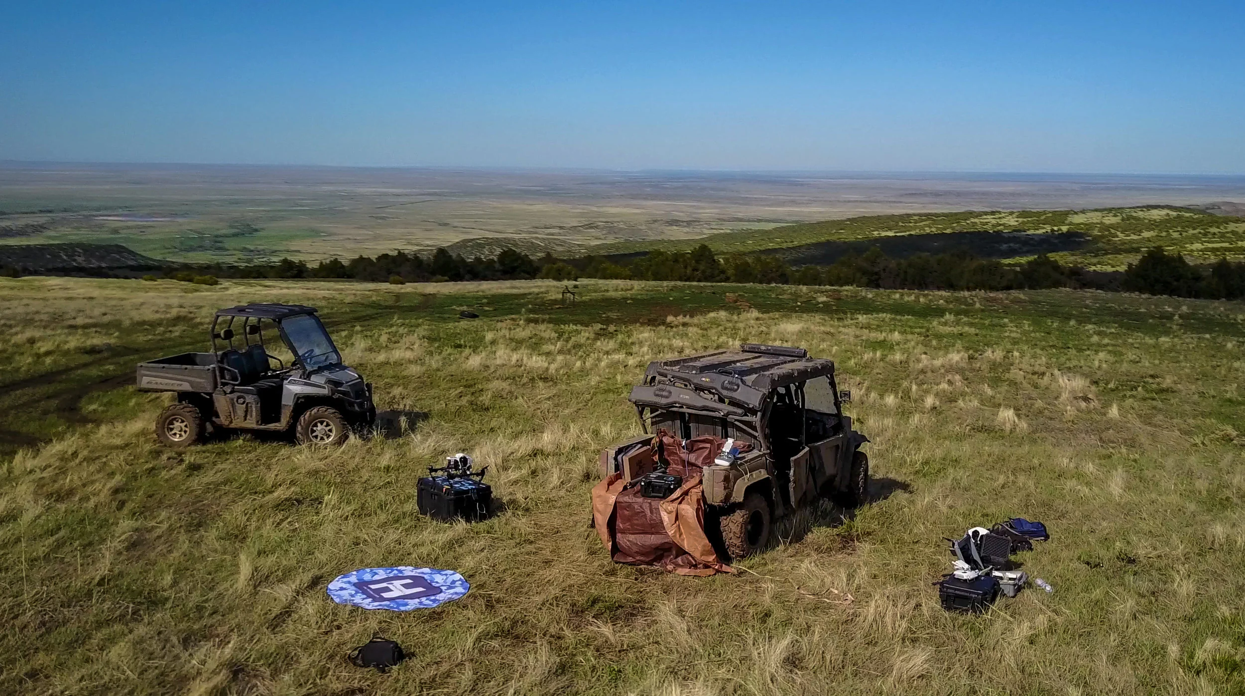Designated takeoff area with a helipad, GPC cases, UTV's and two Inspire 1's while conducting a water density mapping mission. 