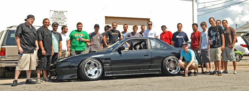 Stephen James with his 240sx, built by the rest of Sumospeed, most of which pictured behind the car.