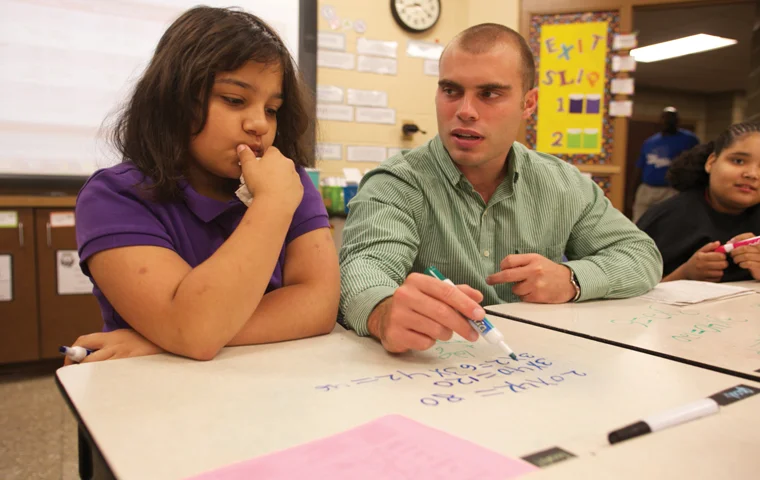 Helping Lodge Elementary student Emily Myers, senior elementary education major Austin Chamberlain goes through different multiplication problems with his fifth grade students. Chamberlain visits this classroom daily as a part of the Pilot Education Program. (Shot for The Shield)