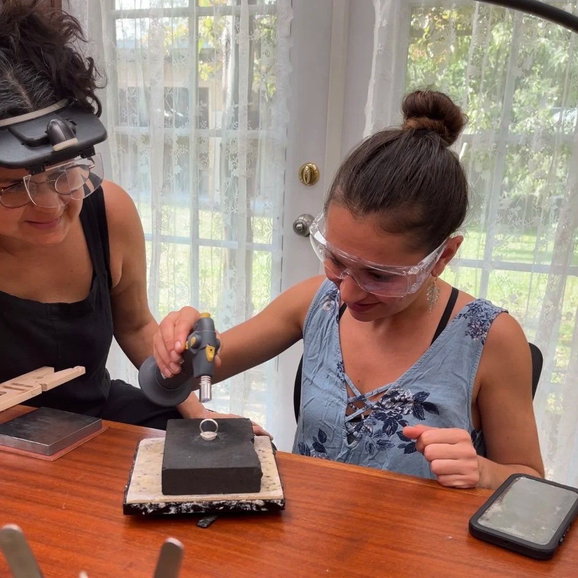 Private ring making workshop near Hilo, Hawaii with instructor guiding a student in a silversmith studio on the Big Island