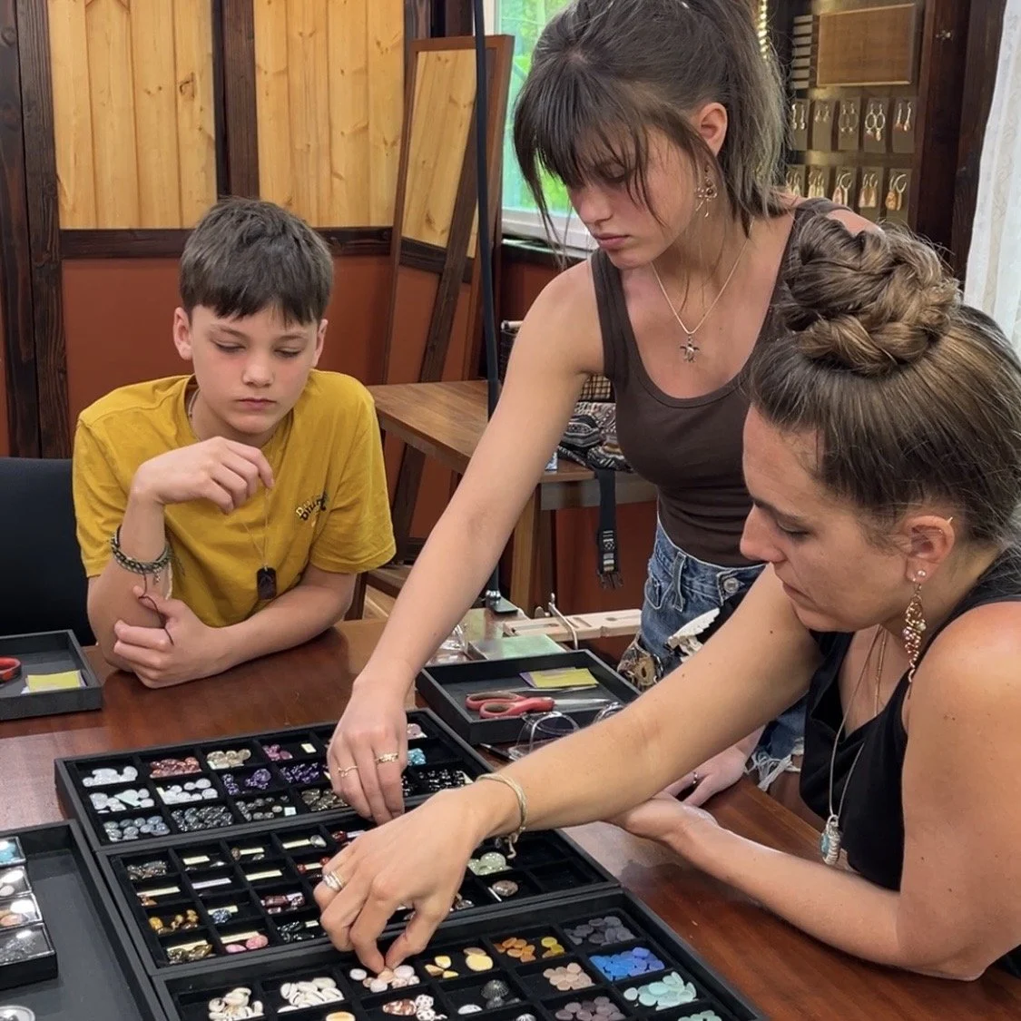 Family taking a hands-on jewelry making class in a silversmith studio near Hilo, Hawaii on the Big Island