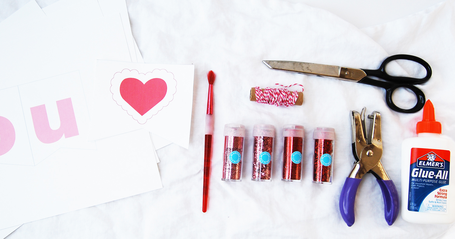 Here are all the supplies you will need: 6 Sheets of Card Stock, Small Paint Brush, Scissors, Elmer's® Glue-All, Paper Punch, Bakers Twine , Martha Stewart Carnelian Red Extra Fine, Martha Stewart Kunzite Pink Extra Fine Glitter , Martha Stewart Garnet Red Tinsel Glitter and Martha Stewart Kunzite Tinsel Glitter (affiliate links). In other words, lots of glitter. 