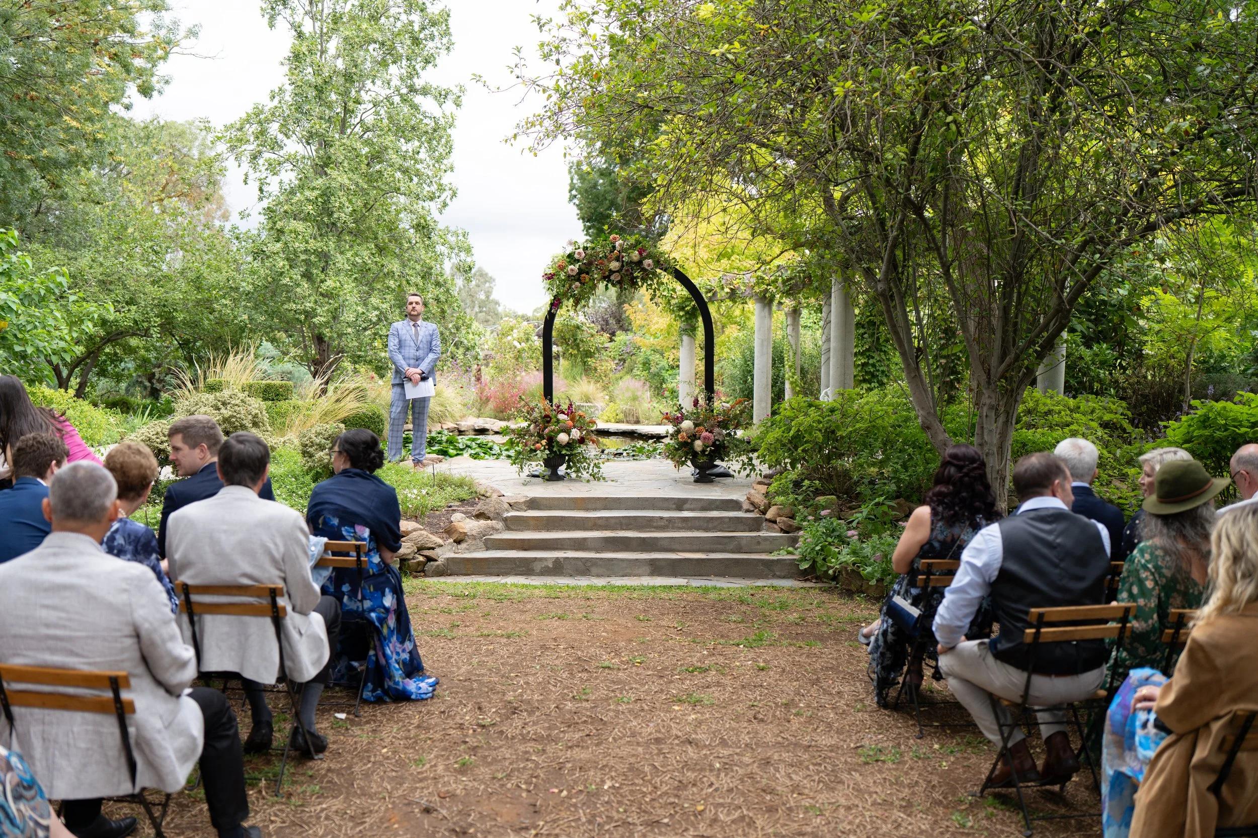 Wide ceremony shot showing guests seated amongst the trees at Al Ru Farm