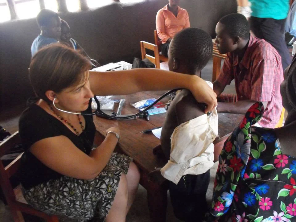 Dr. Laura examining a child on a health outreach clinic with PDI, 2013, Bududa (photo credit Lisa Umphrey)