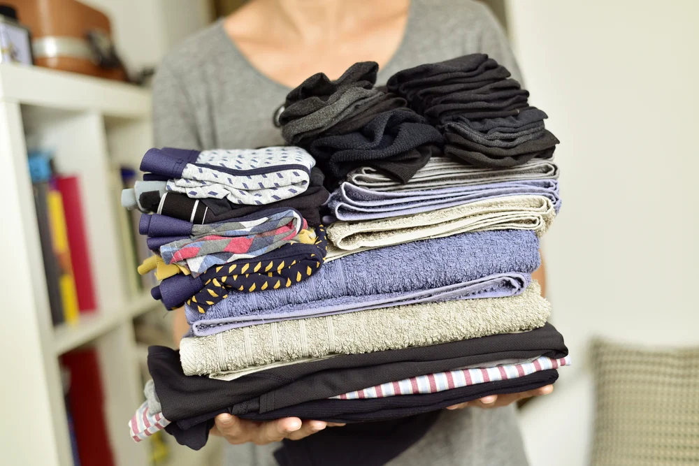 A homeowner holding folded laundry