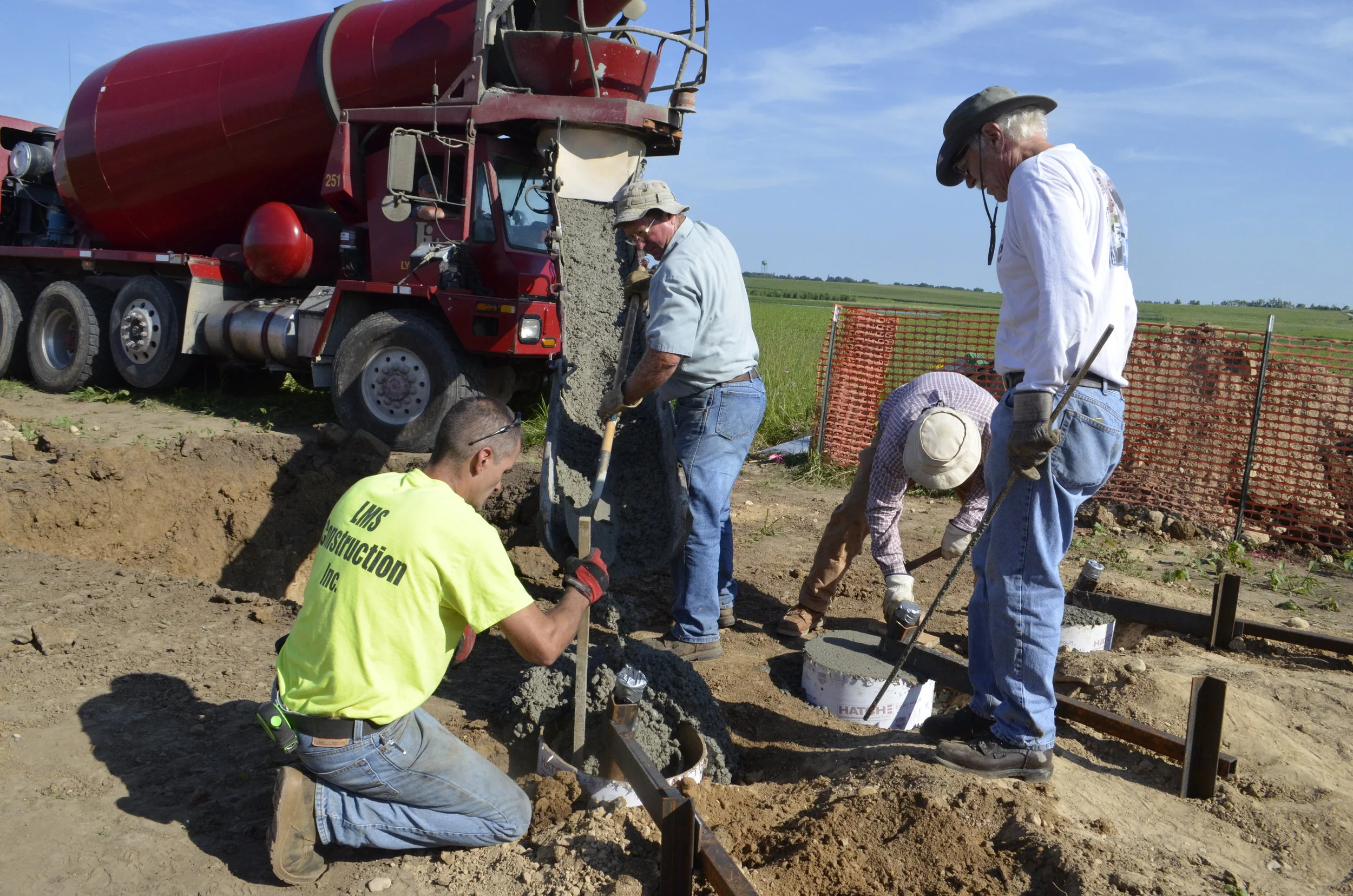 Concrete is poured for the footings to hold the wings.