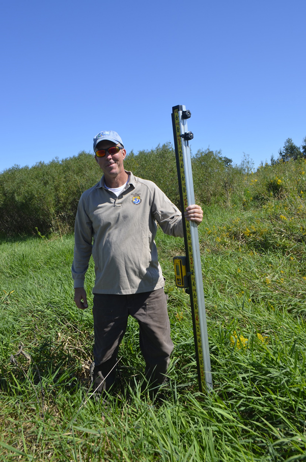 Kurt Waterstad posing with the laser elevation reader. Photo by Mark Martin.