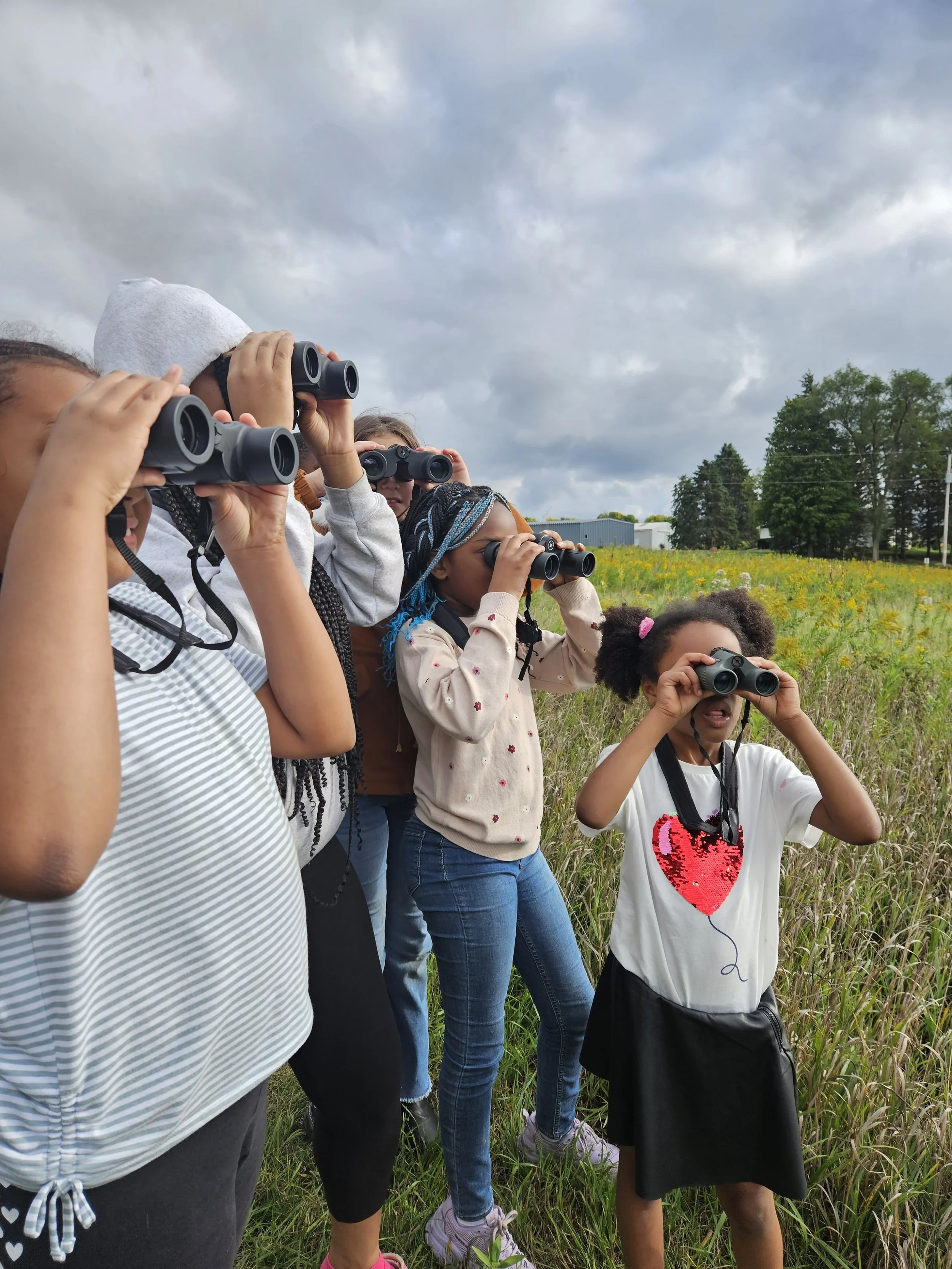 Kids use binoculars to bird (Mickenzee Okon).