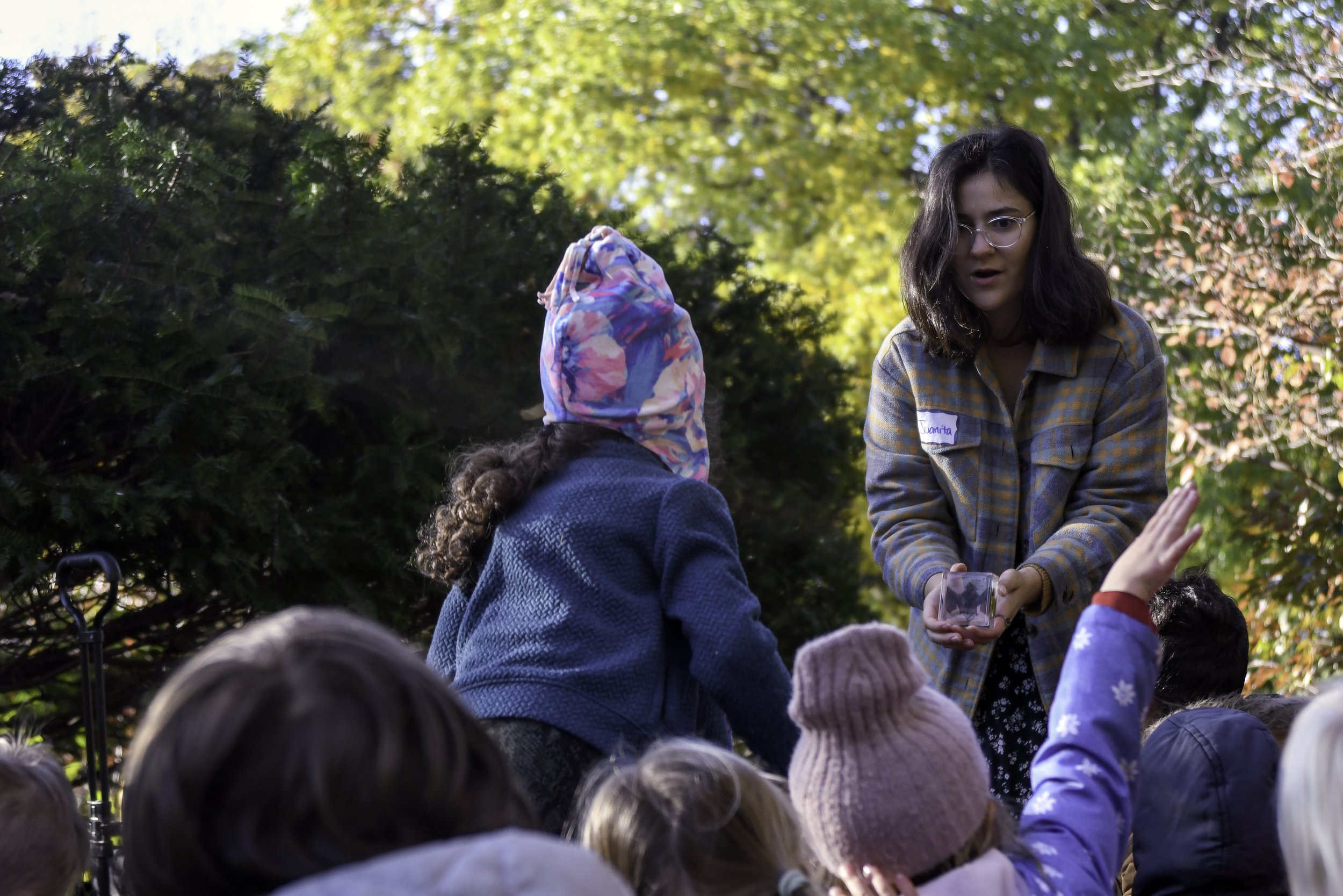 Juanita shows a bat specimen to kindergarteners on a fall day