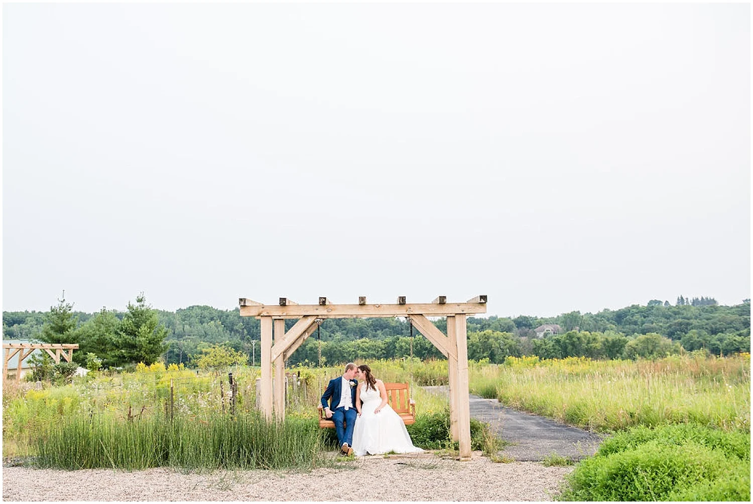 bride and groom on bench swing