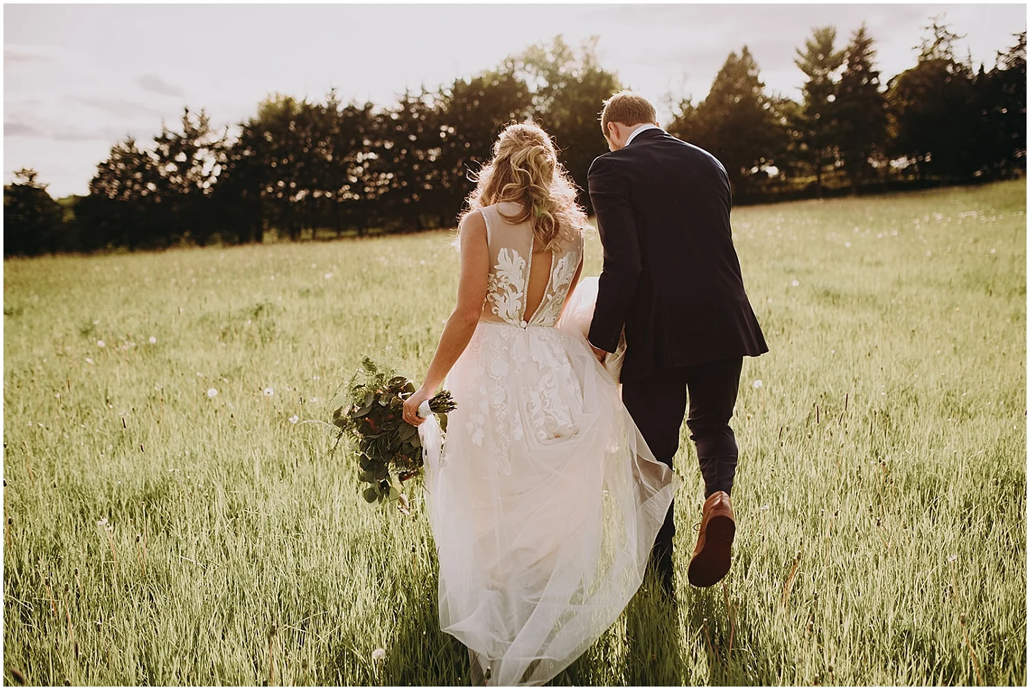the bride and groom holding hands in the field