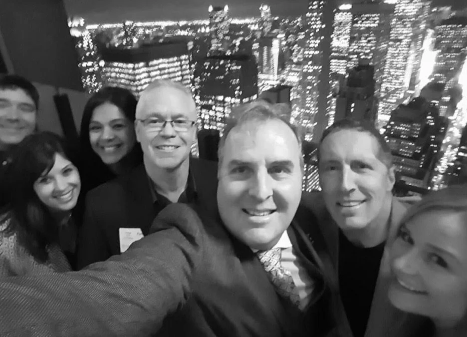 Megan Gouldner with a corporate consulting group against a city skyline at night