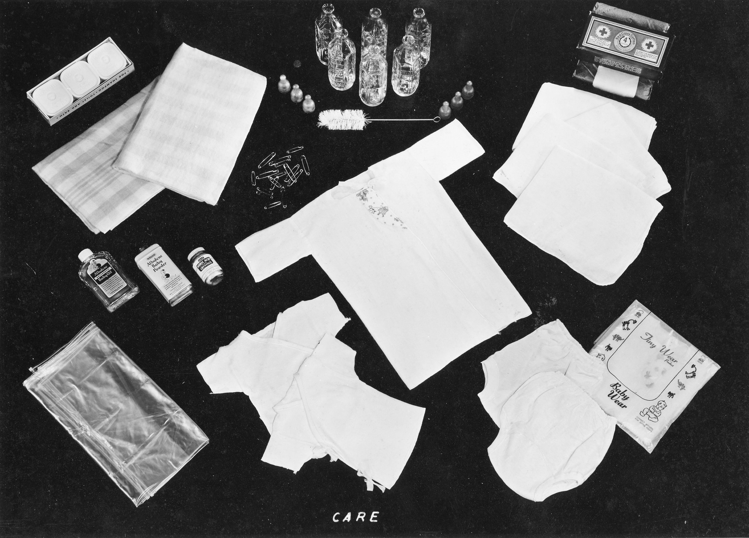 This photograph shows a CARE package specifically for an infant. it includes clothing, cleaning, and care supplies.