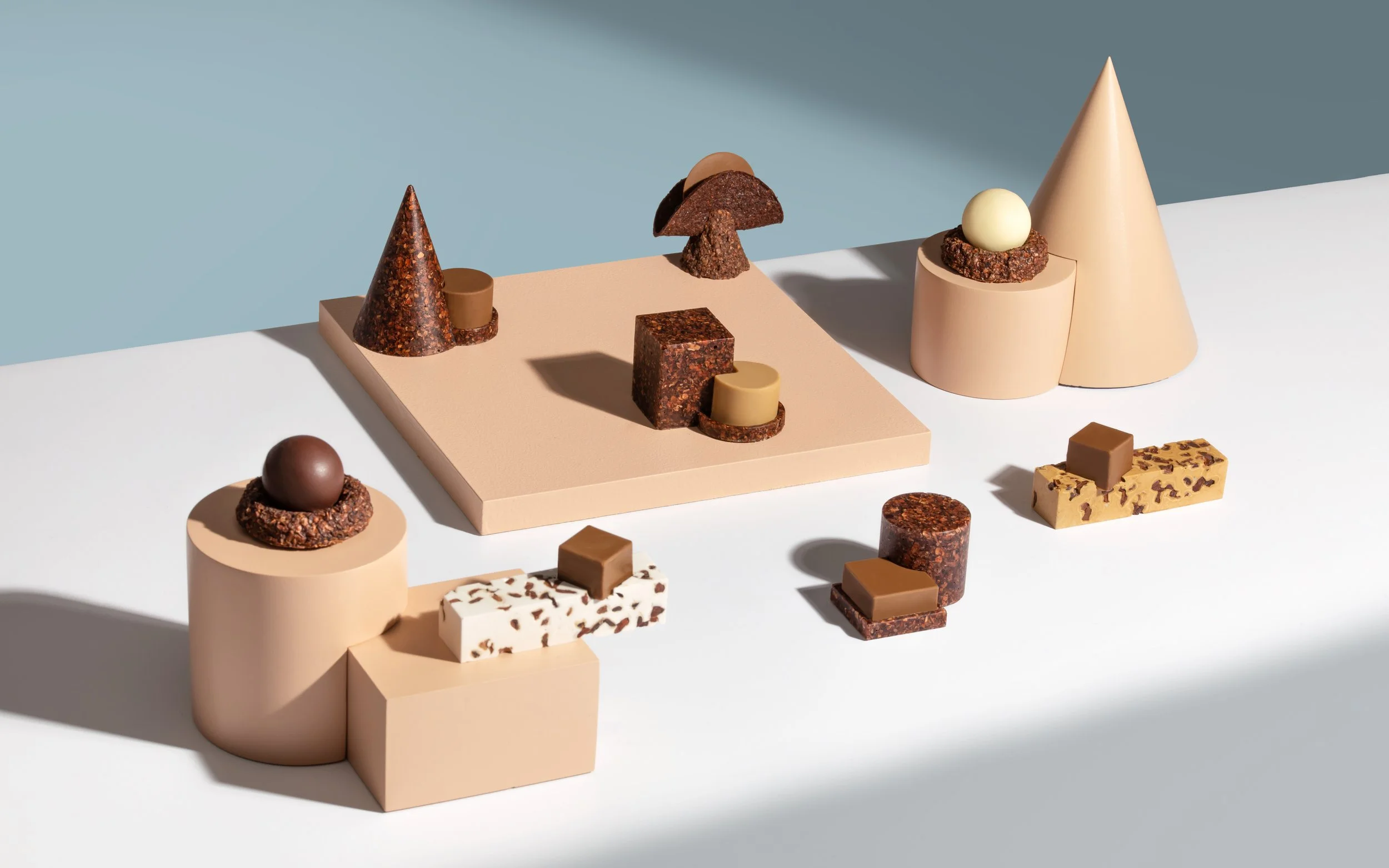 Sculptural chocolate installation created for Omnom featuring geometric plinths and artisanal chocolate forms inspired by Icelandic memory and landscape