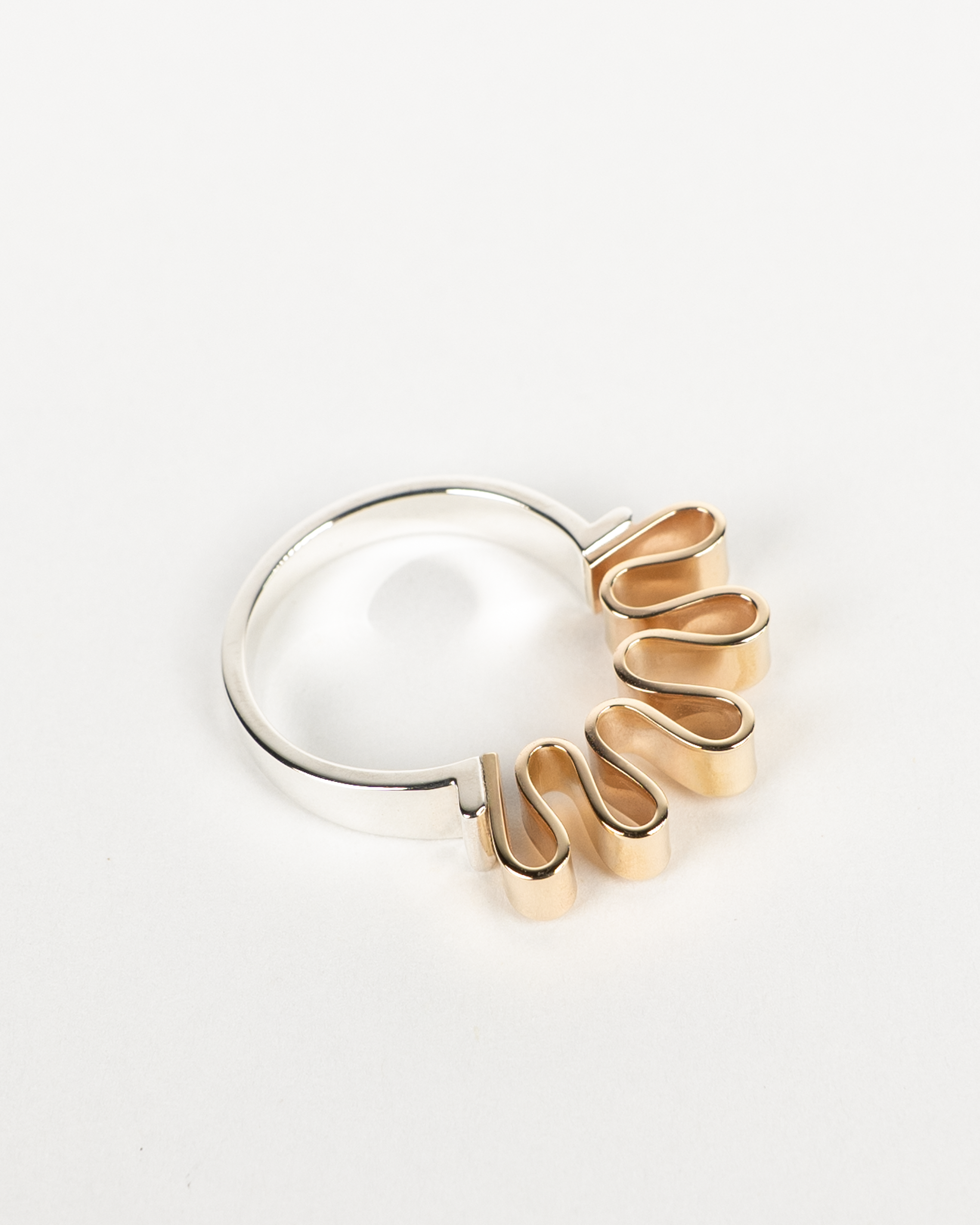 Close-up of Ribbon ring in silver and gold showing folded ribbon-like metal form