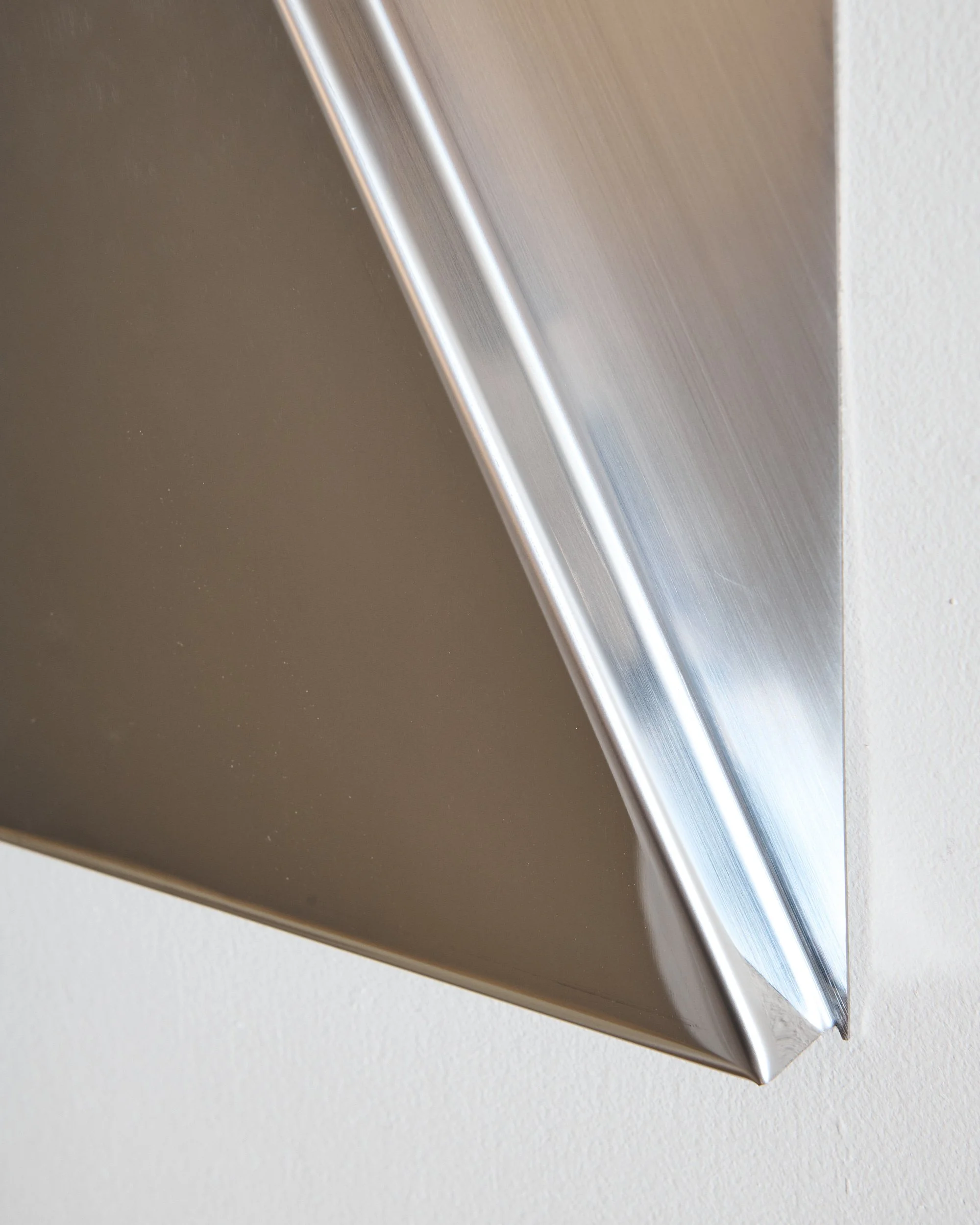 Detail of brushed and polished stainless steel mirror surface