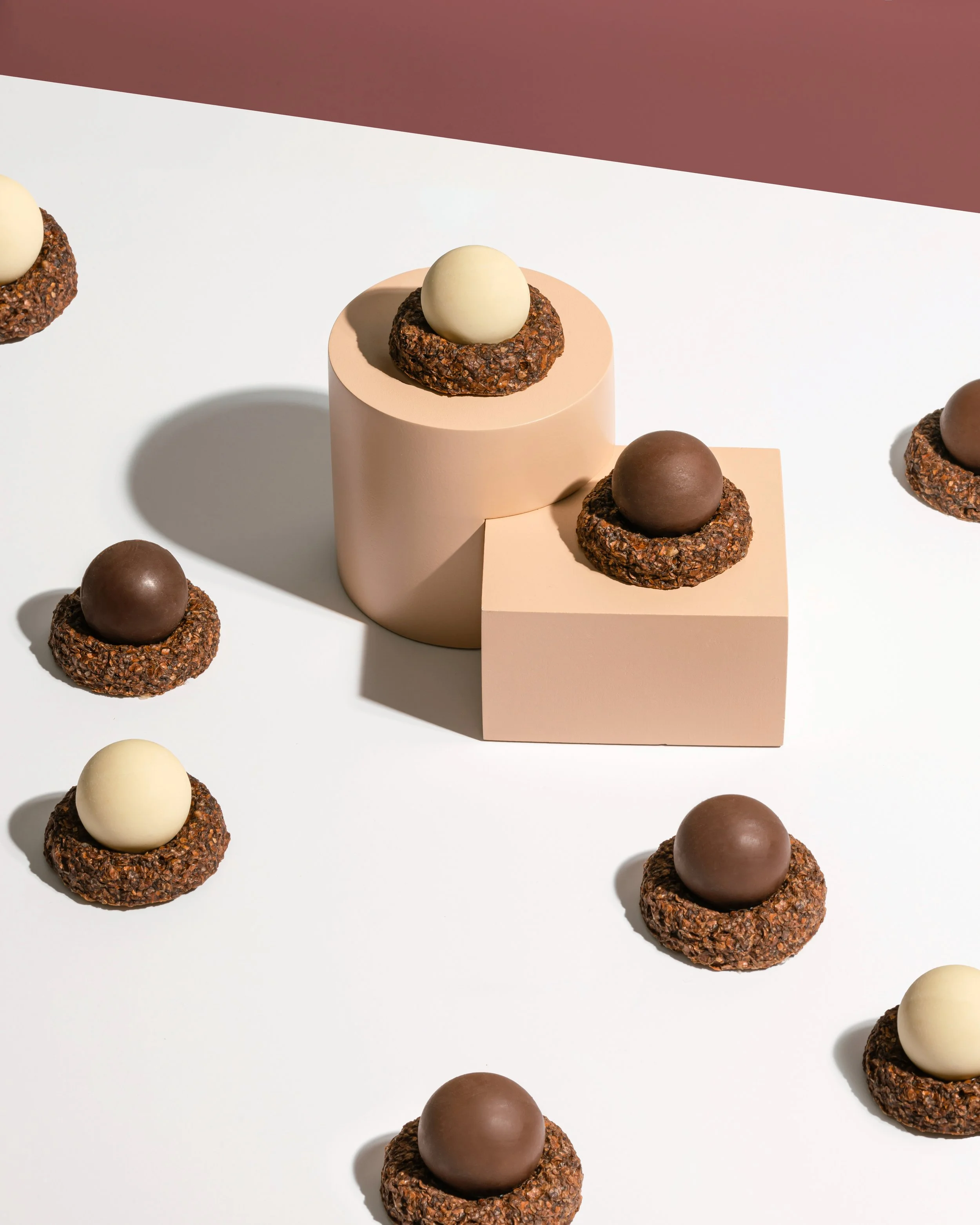 Sculptural chocolate desserts with textured bases presented in geometric installation for Omnom collaboration