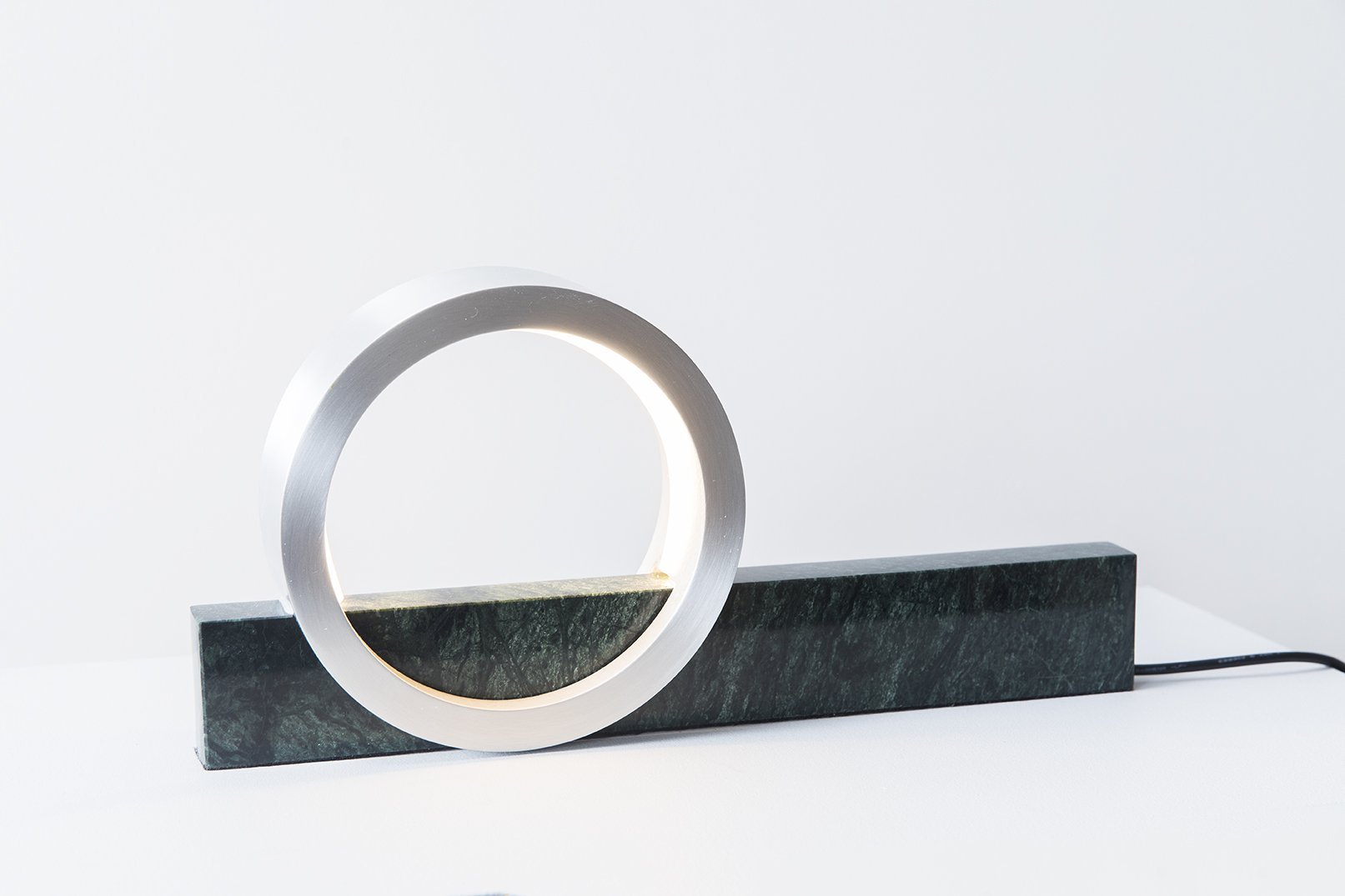 White Composition Light table lamp with illuminated circular silhouette on marble surface