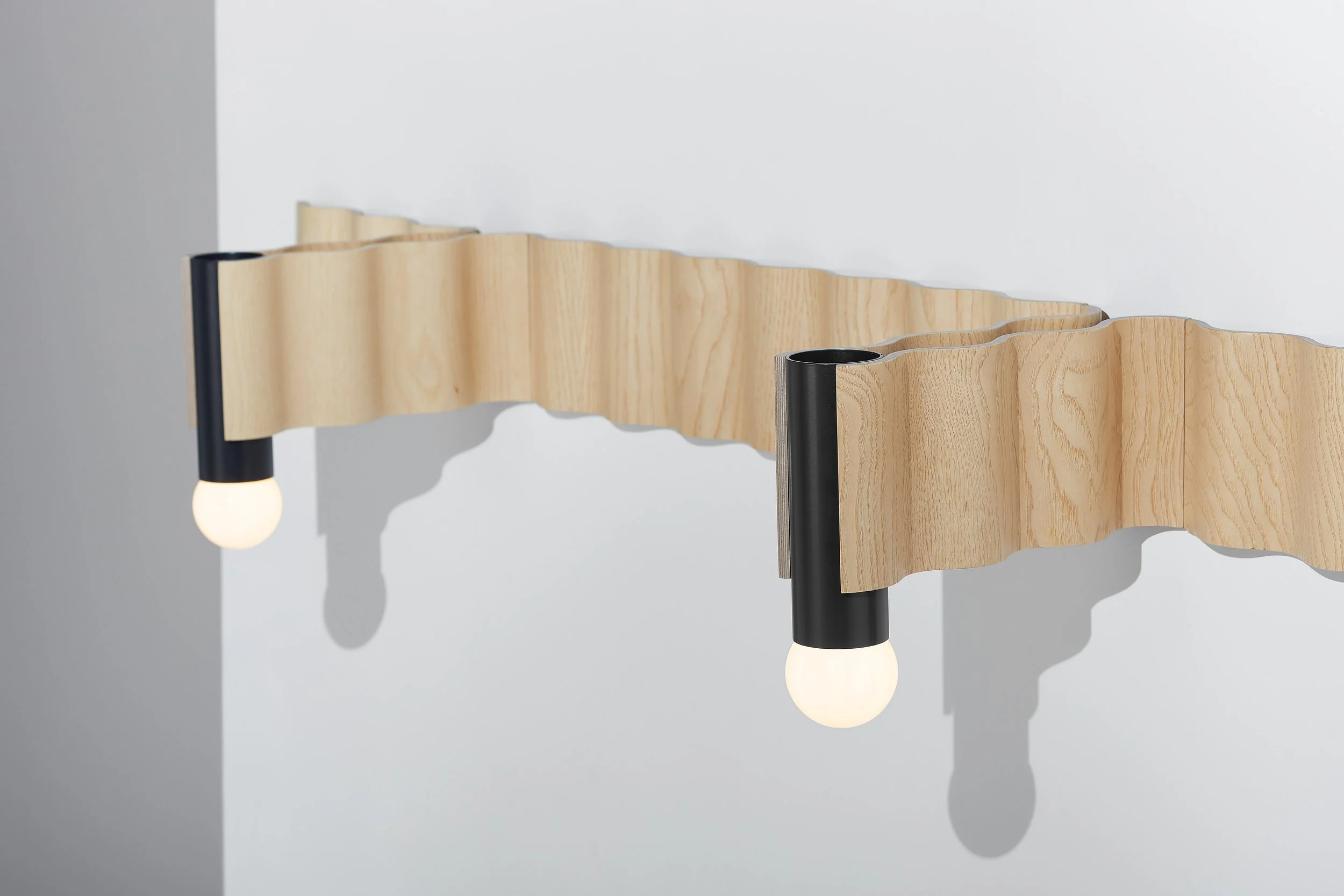 Close-up of Corrugation lighting system showing formed ash veneer and black aluminium fittings