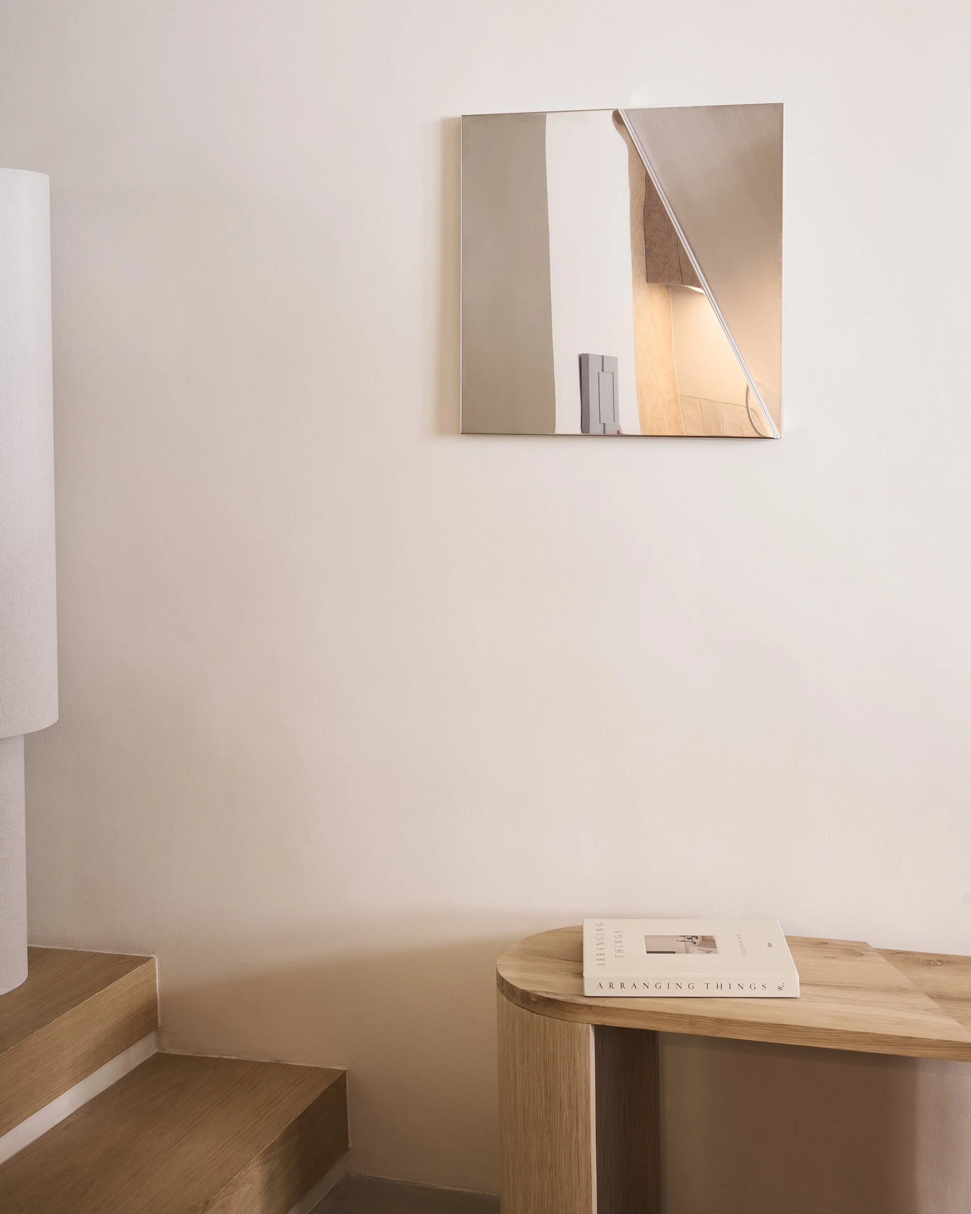 Modern folded metal wall mirror in polished stainless steel