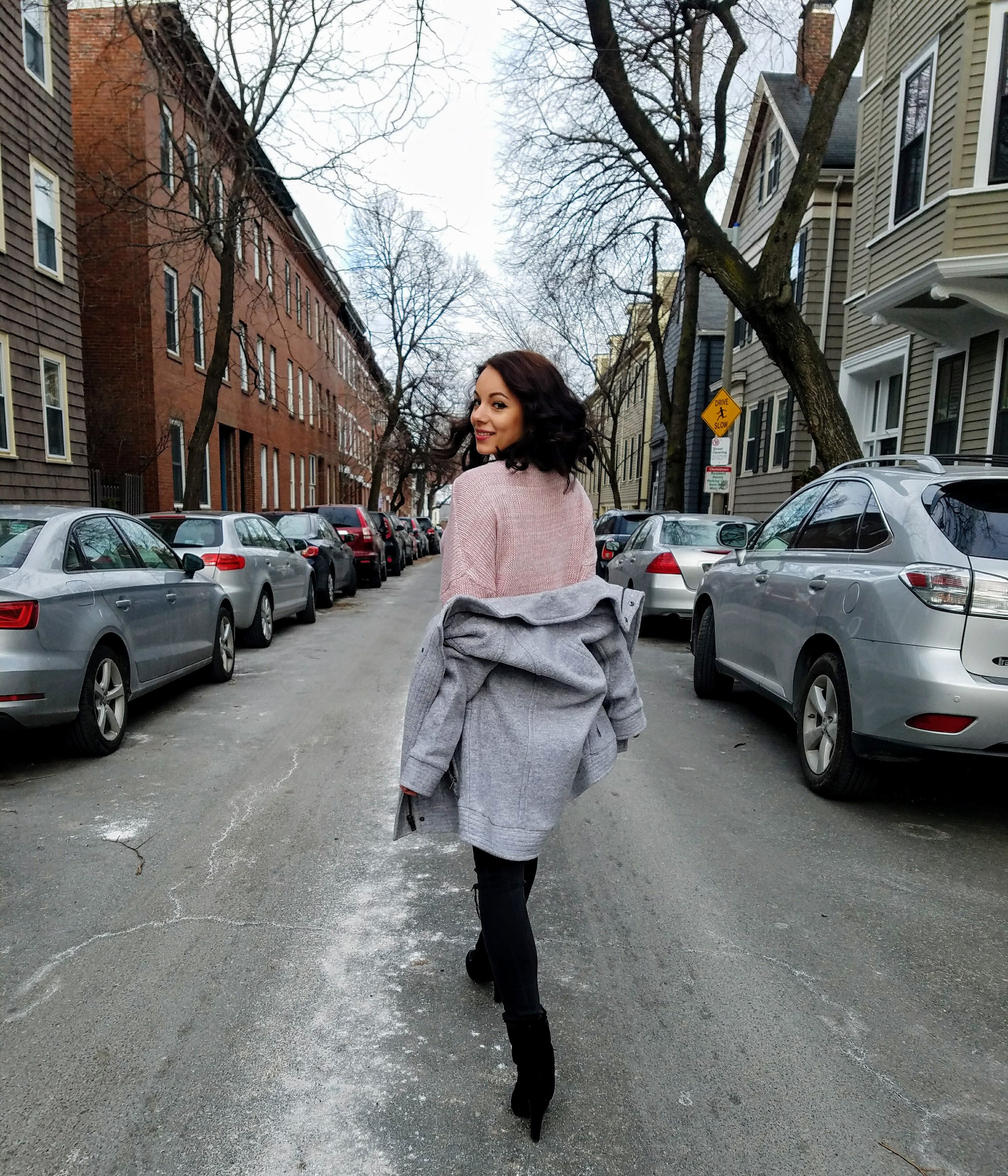 A girl in Boston. Blogger. Pink sweater, gray jacket, ripped jeans, and black booties. Valentine's day.