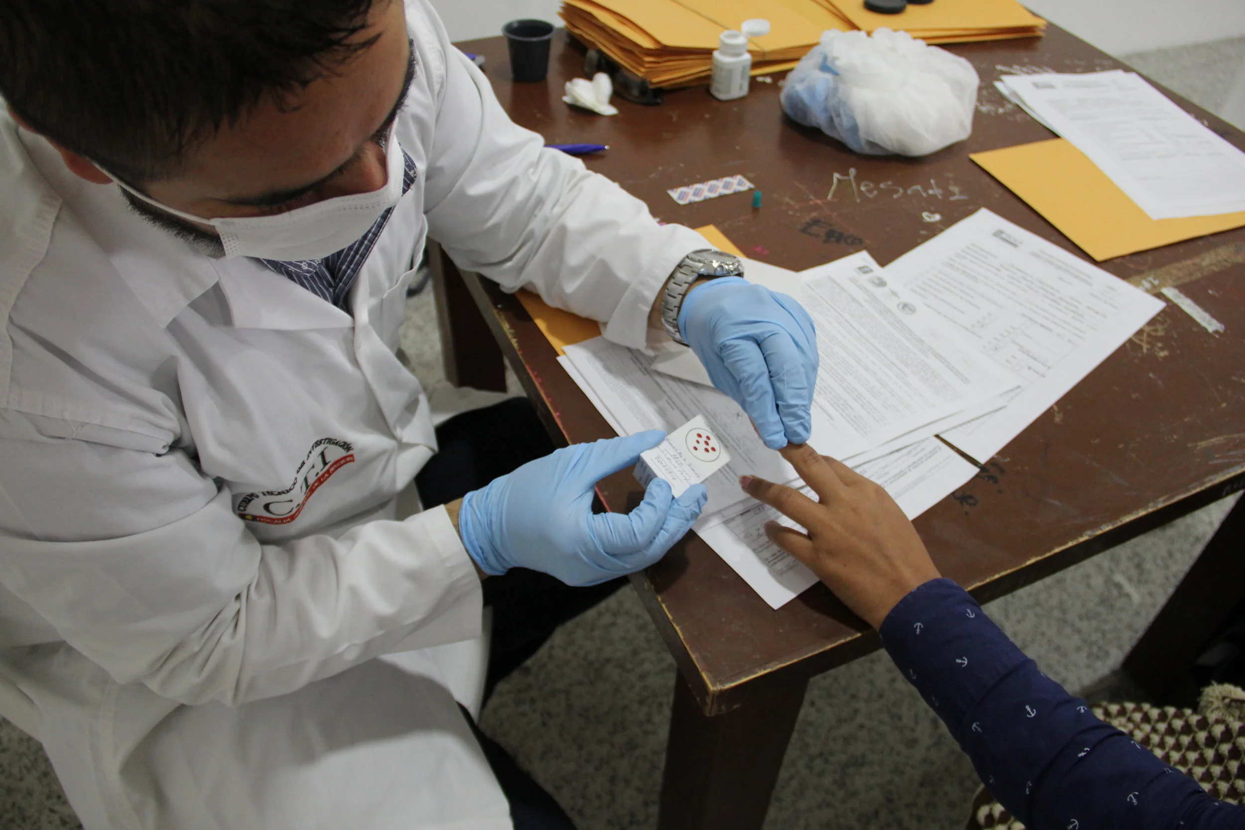  A forensic technician takes a blood sample from a woman looking for her missing father in Sogamoso, Colombia. The DNA extracted from the blood will be entered into the country's CODIS database and compared with unidentified bodies in an effort to fi