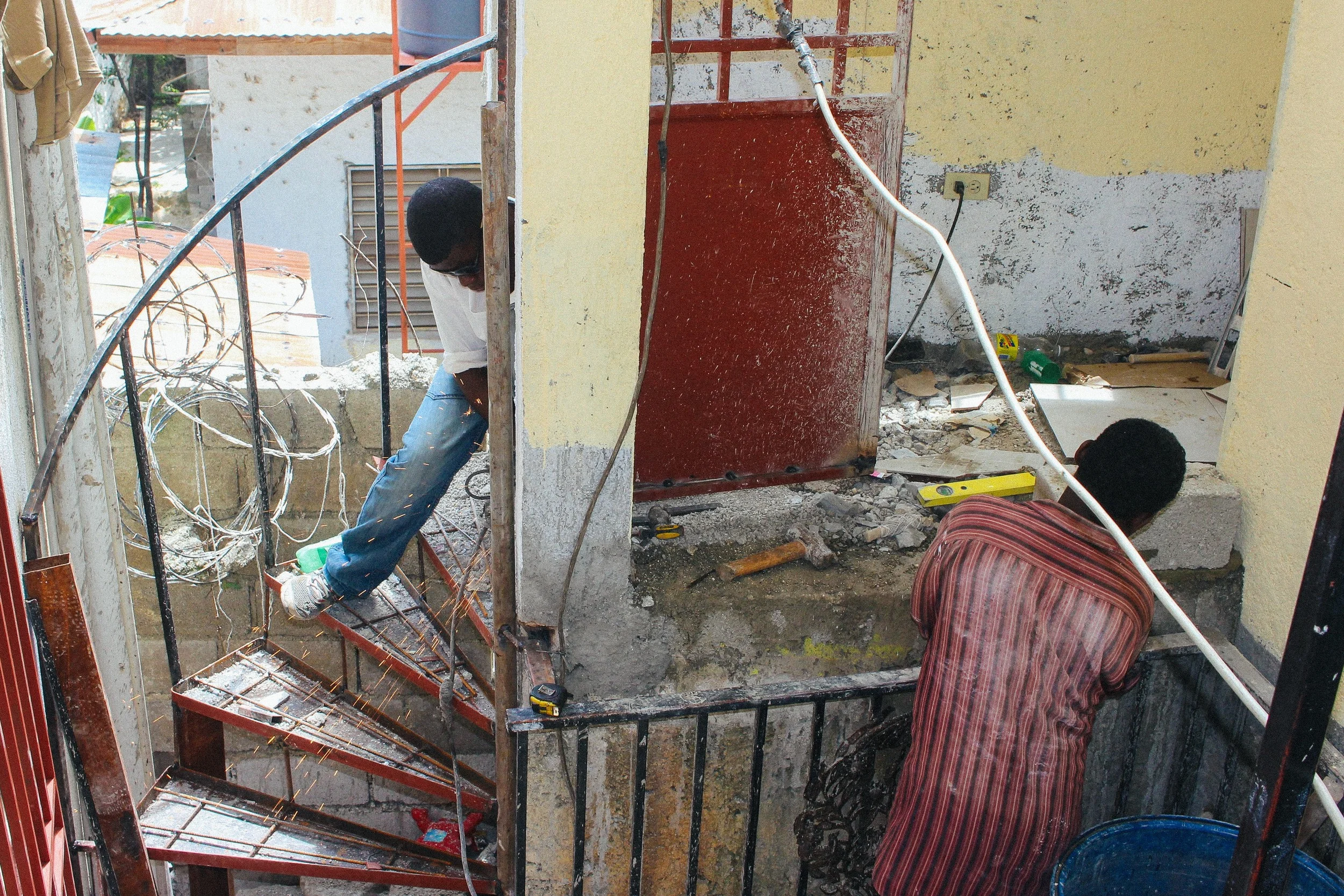 TIMKATEC professors and students completed the design and construction of the women's bathroom. Two of them are pictured here working on the bathroom entryway. MCC photo/Katharine Oswald