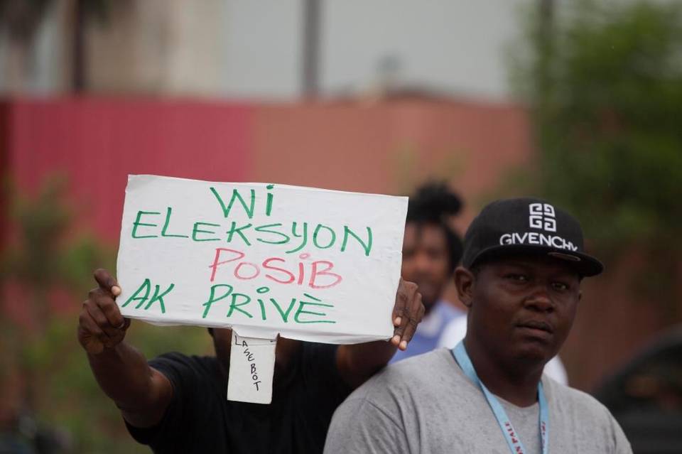 Photo: Dieu Nalio Chery, AP. A demonstrator holds a sign that reads ""Yes the election is possible with Privert" from Miami Herald article, June 2016
