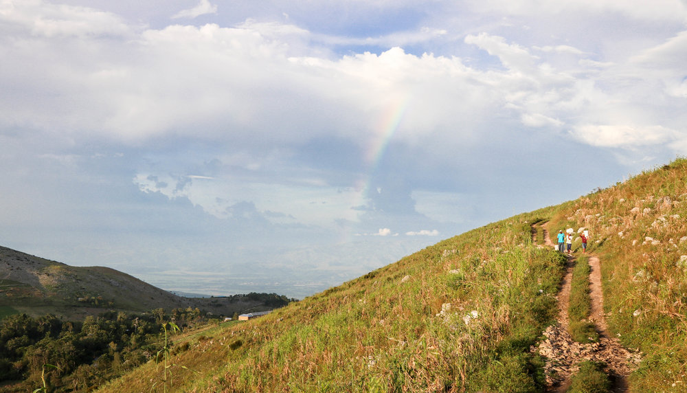 High in the mountains of Verrettes 6th section in Artibonite, Haiti, people whose houses were destroyed by Hurricane Matthew make the two hour trek by foot back home with MCC relief supplies two days after the storm passed.
