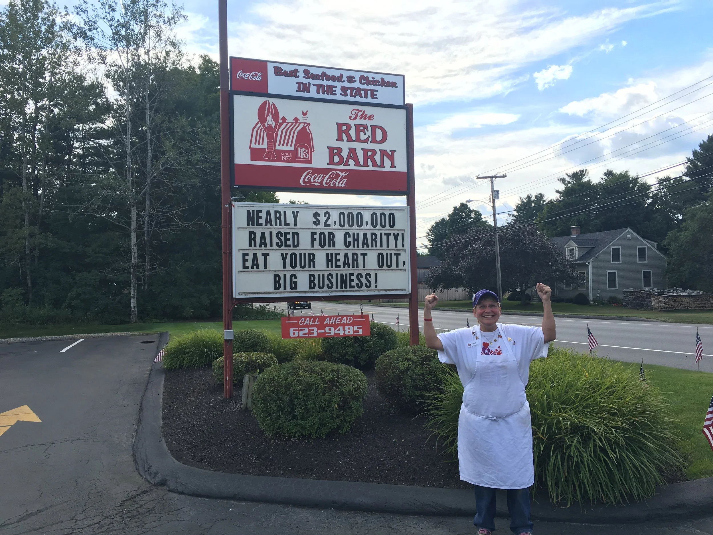 Laura Benedict stands in front of the red barn's road sign with an urge to businesses to continue giving and doing good in their communities. 
