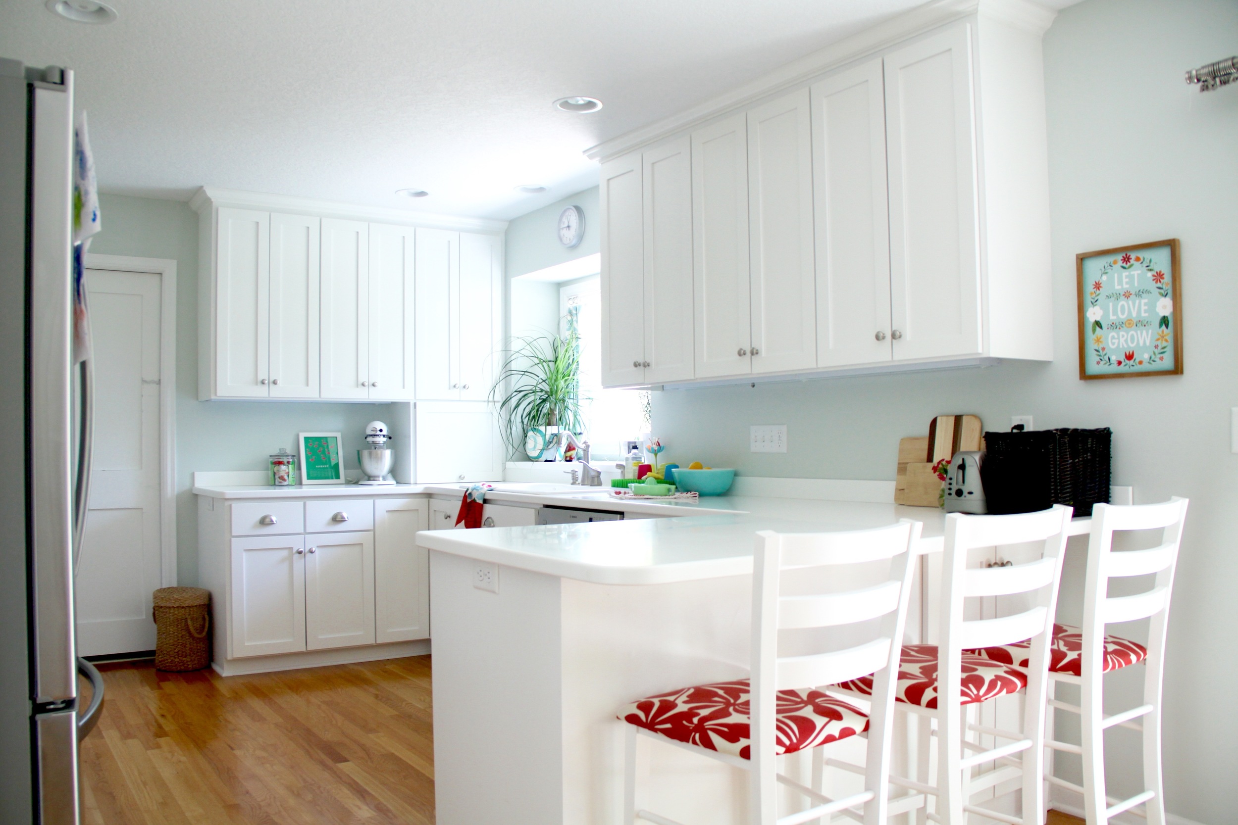 White Kitchen with Shaker Style Cabinets and Warm Wood Floor
