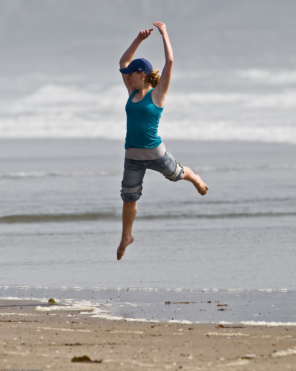 Girl dances at water's edge on Morro Strand State Beach