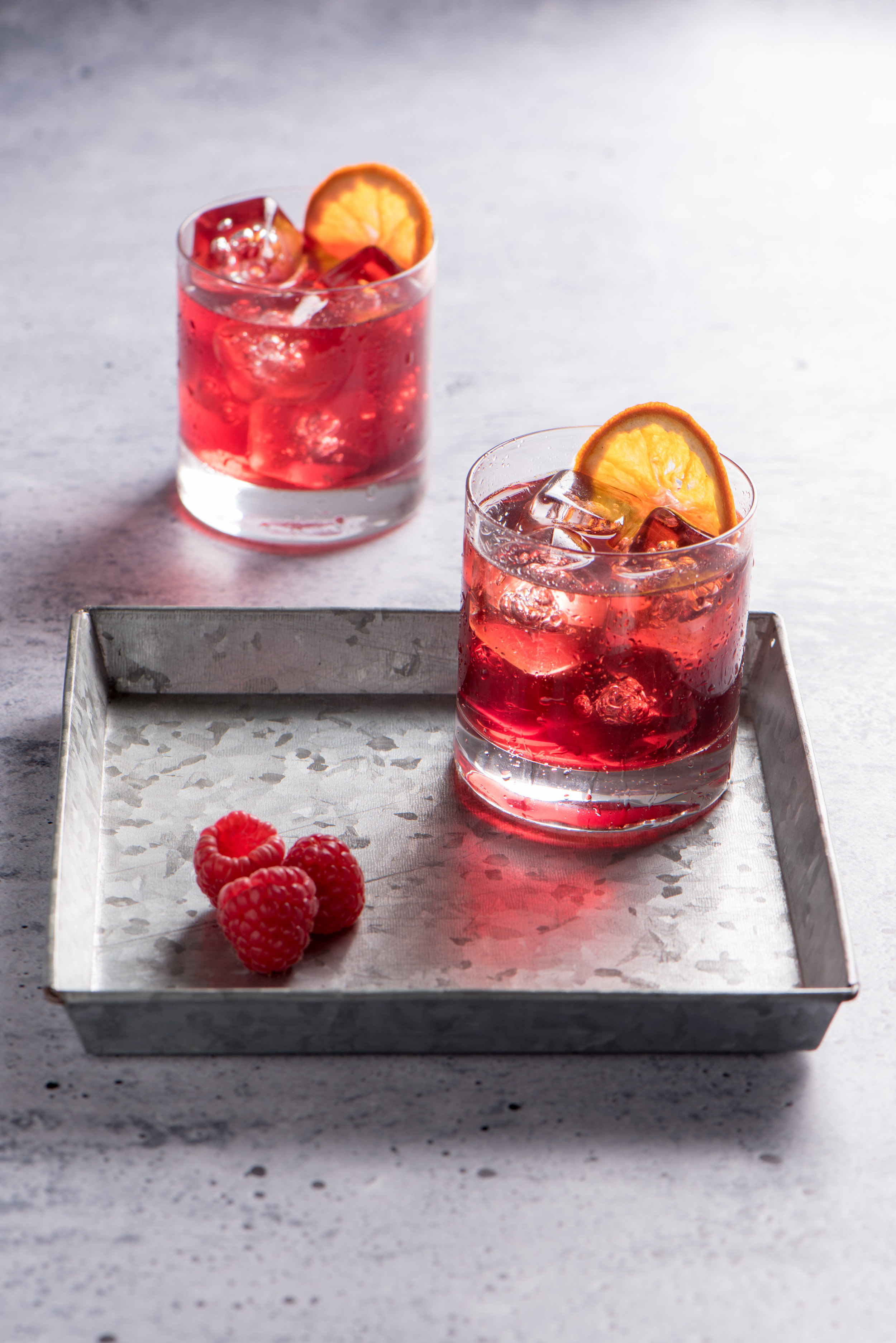 Red Cocktail with orange slices and raspberries