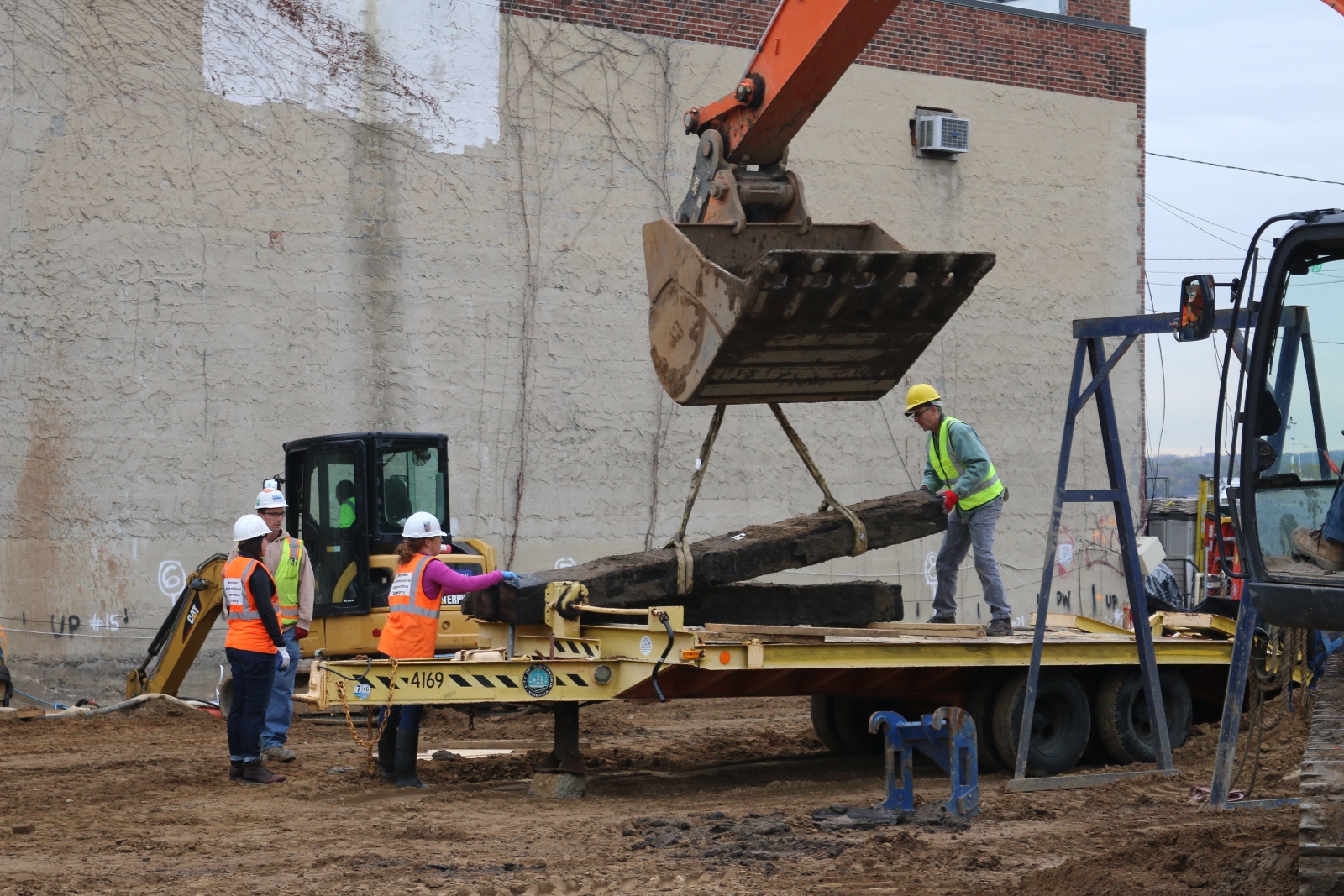  City of Alexandria archeologists and conservators from the MAC Laboratory secure 12 foot sections of the warehouse beams onto a flatbed trailer for transportation.       