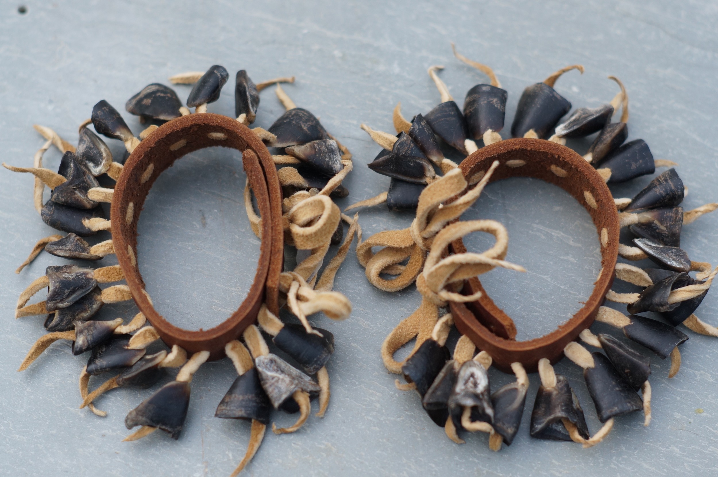 A pair of dewclaw anklets I made. Braintanned buckskin, bark tanned deer skin and deer dewclaws.