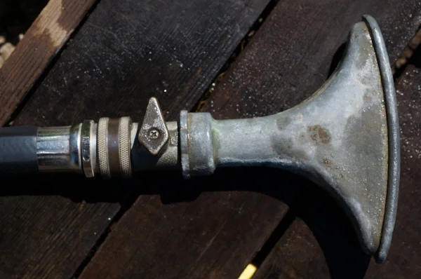 Most hoses should have a shut off valve already. Putting a valve on the sprayer is usually going to be a disadvantage, let a lone redundant.
