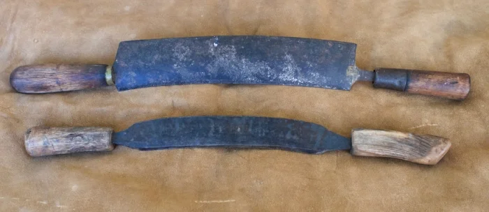 For whatever combination of reasons, these are the tools I’m most likely to grab first. The. traditional wide knife is worn back, making the edge closer in line with the handles, which is more stable when doing hard work. The second is forged from a wagon leaf spring, 3/16” thick, 20” long, 1.5” wide. The working edge is only 9.25”, but there is plenty of working room between the handles. If I made a knife like this again it would have a 10” or 11” working edge. the handles are antler.