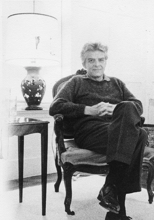 In his slacks at home