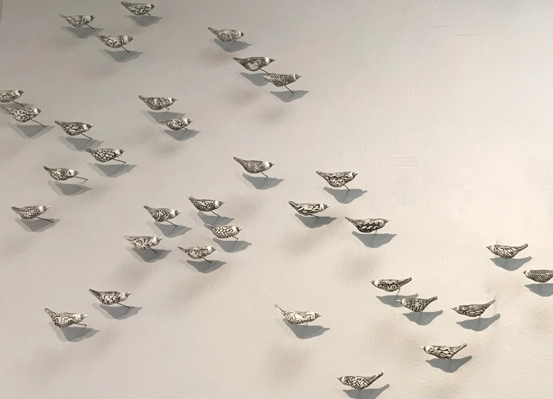 Each bird is individually handbuilt using high fire stoneware clay and fired multiple times with slips and stains. The highly textured pieces are stamped using stamps that I make from the soles of my children’s shoes. The permanently attached wire enables the bird to go directly into the wall allowing the installation to be compact or very expansive. These birds look stunning in a group of 3 or a flock of 300.