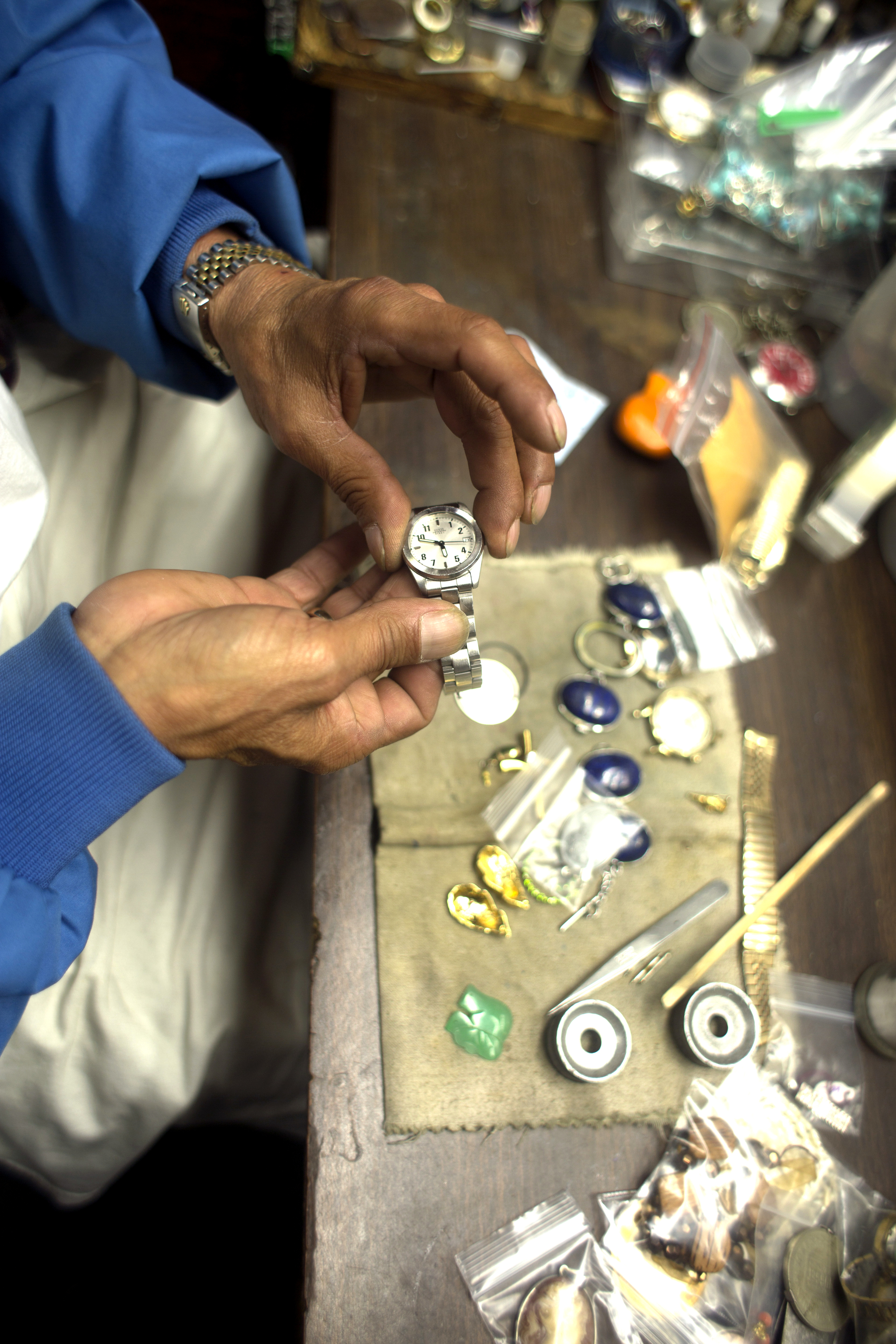 Nelson Diaz owner of Tony's Watch and Jewelry Repair changes a battery in a watch at his desk Wednesday February 25, 2015.