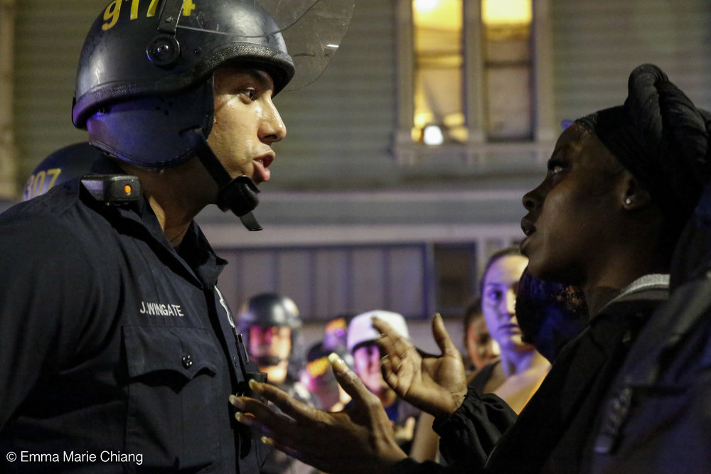  Rahmana Ali talks with an Oakland Police officer during an anti-Trump protest through the streets of downtown Oakland Wednesday Nov. 9 2016. The Oakland Police blocked protesters from marching down Washington Street. Photo by Emma Chiang 