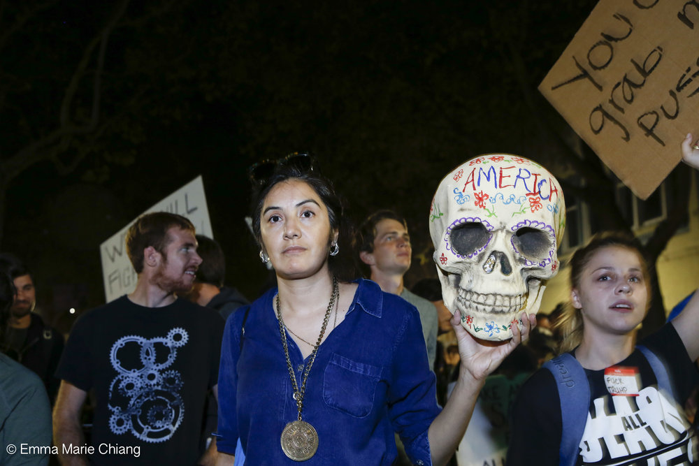  Aide Rodreguez holds a skull that reads "American" while walking with hundreds of anti-Trump protesters through the streets of downtown Oakland Wednesday Nov. 9 2016. Photo by Emma Chiang 