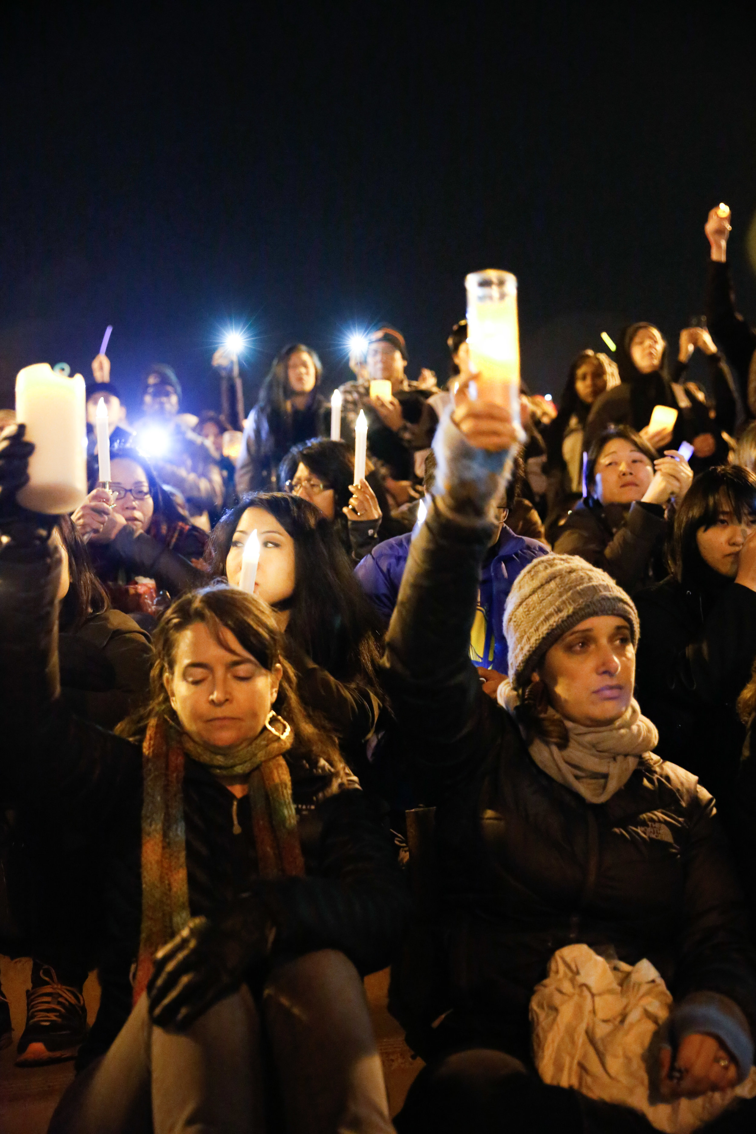  Mourners raise candles during a moment of silence at a vigil at Lake Merritt Pergola on Monday December 5, 2016. in honor of the 36 people who died in the Oakland Fire at the Ghost Ship warehouse party Friday, December 2.&nbsp; 