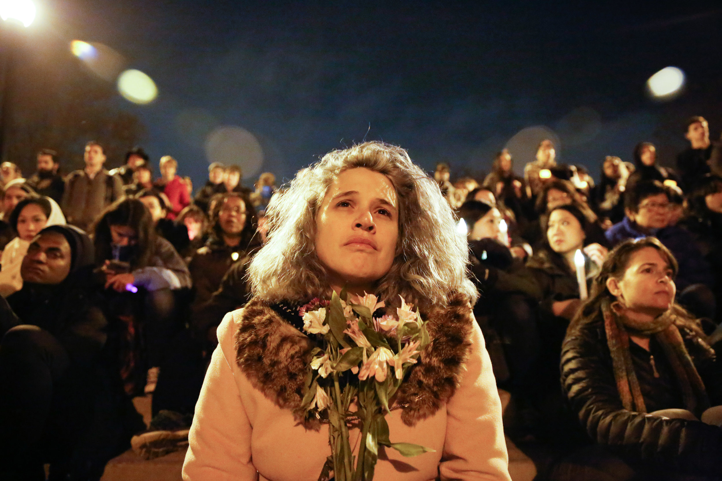  A woman holds flowers in honor of the 36 people who died in the Oakland Fire at the Ghost Ship warehouse party Friday, December 2. held at at Lake Merritt Pergola on Monday December 5, 2016.&nbsp; 